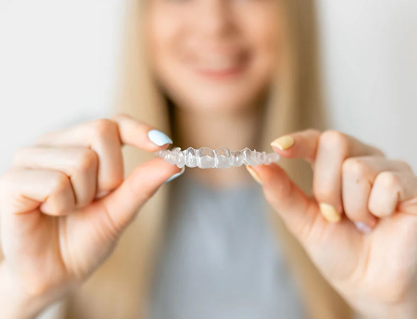 Happy Patient holding clear aligners