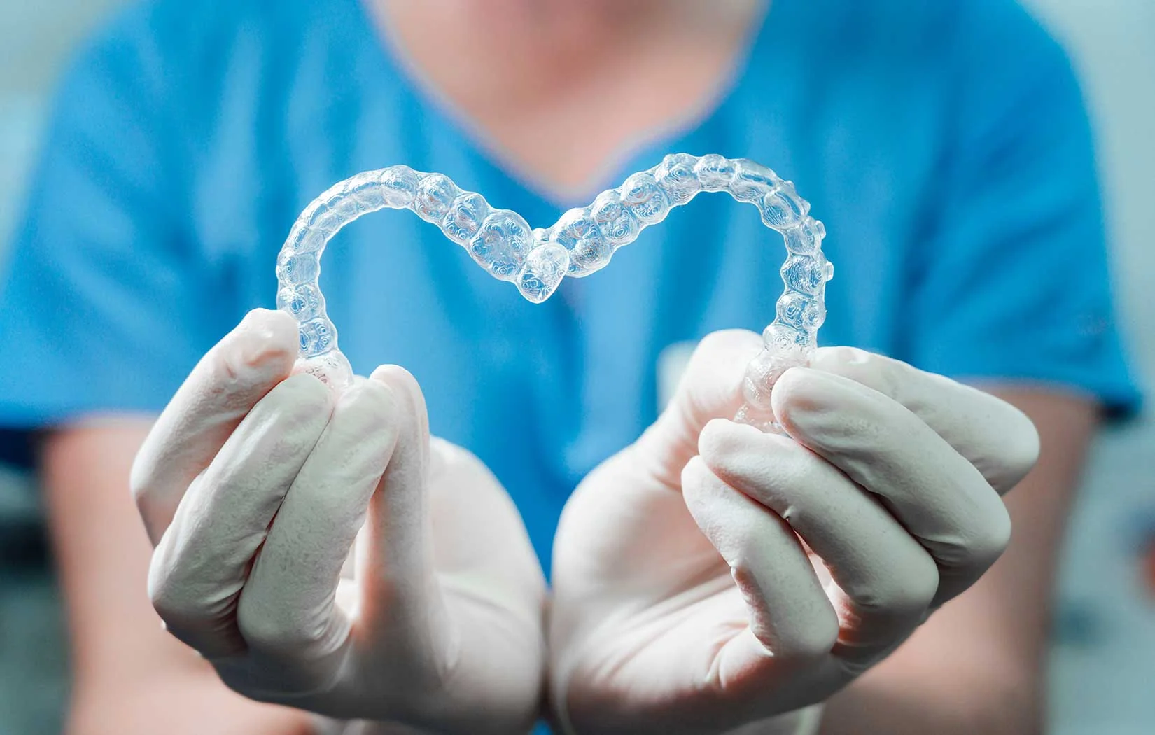 Dentist holding Invisalign Clear aligners